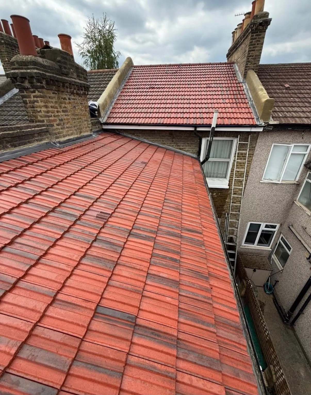 Red tiled roof slopes beside neighbouring houses