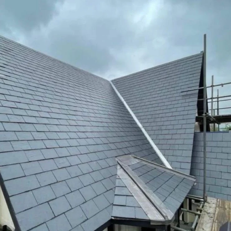 Slate roof slopes and valley junction beside scaffolding