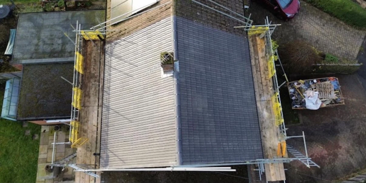 Overhead view of tiled roof slopes and surrounding scaffolding