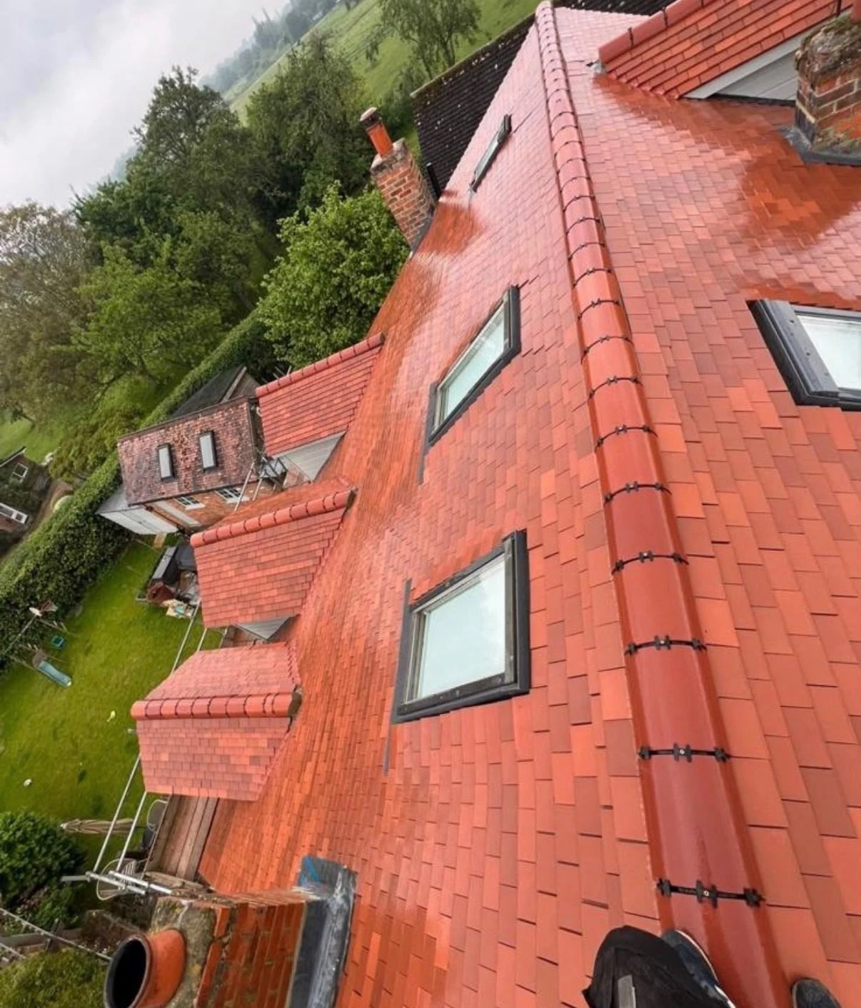Red tiled pitched roof with several roof windows