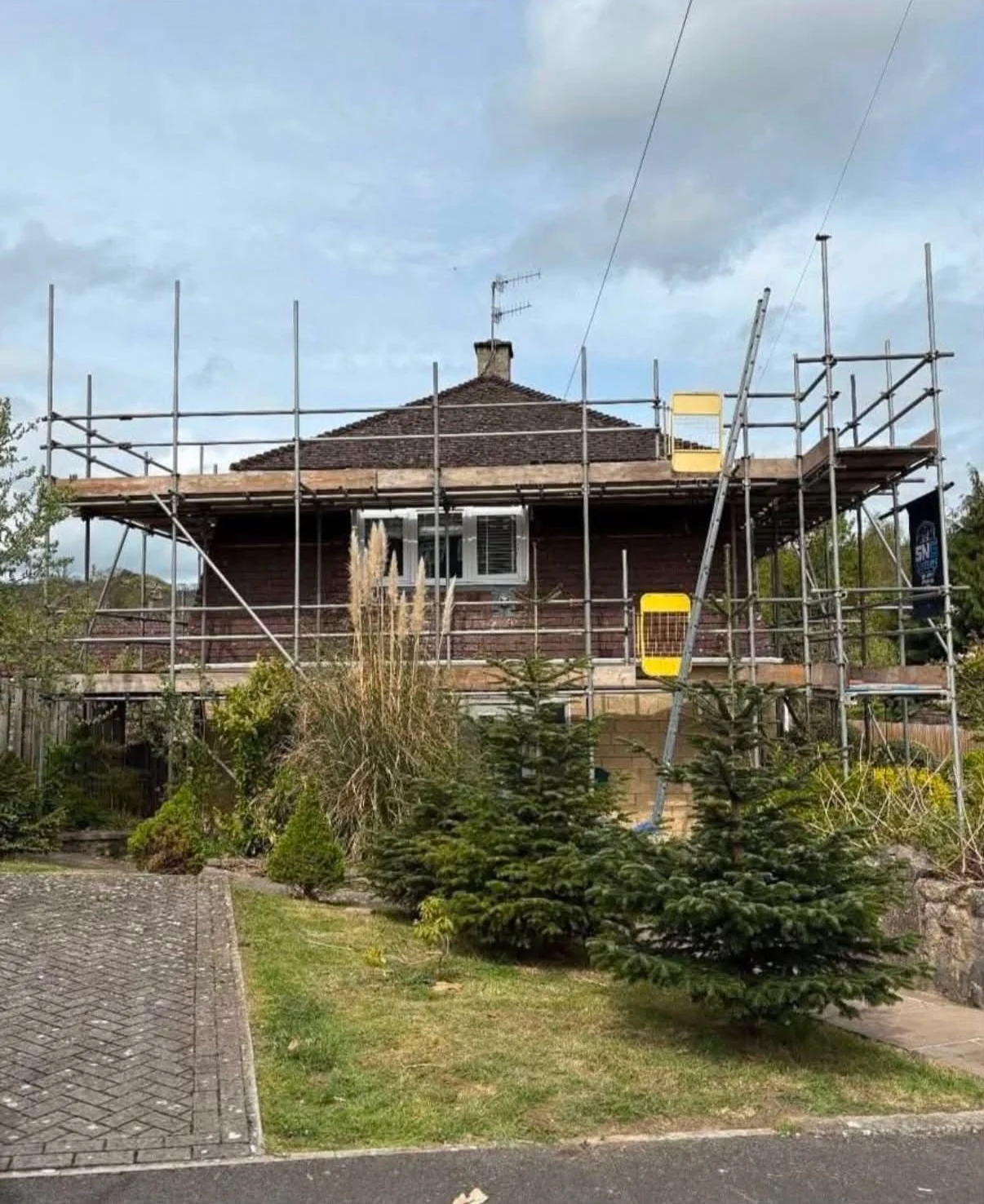 House roof surrounded by scaffolding before roofing work