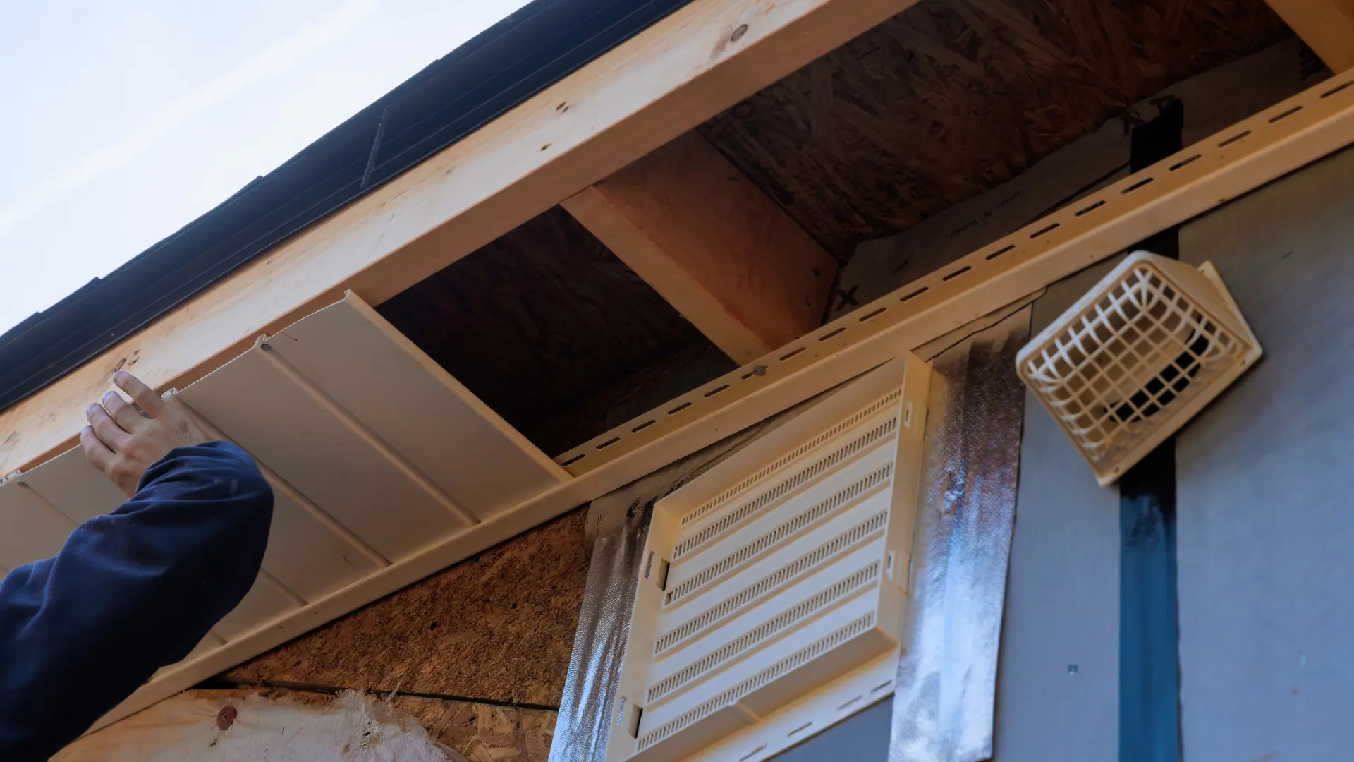 Soffit panels being fitted beneath the roof edge