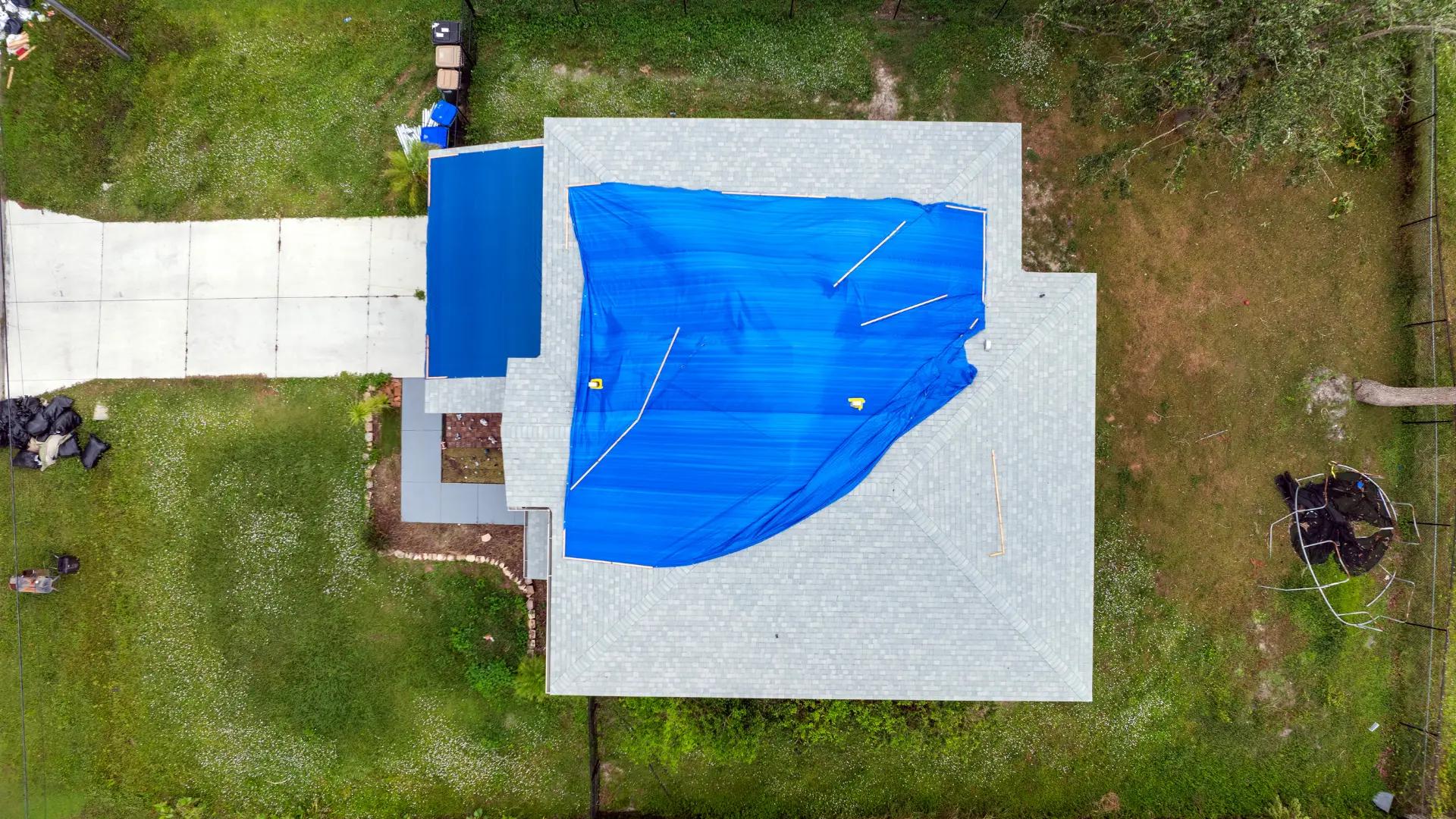 Blue temporary tarpaulin covering a roof viewed from above